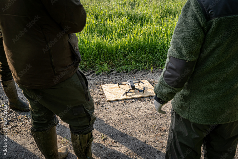 Vorbereitung der Drohne mit Wärmebildkamera für die Rehkitzrettung auf einen Feldweg neben einer Wiese. Vorbereitung der Drohne mit Wärmebildkamera für die Rehkitzrettung auf einen Feldweg neben einer Wiese.