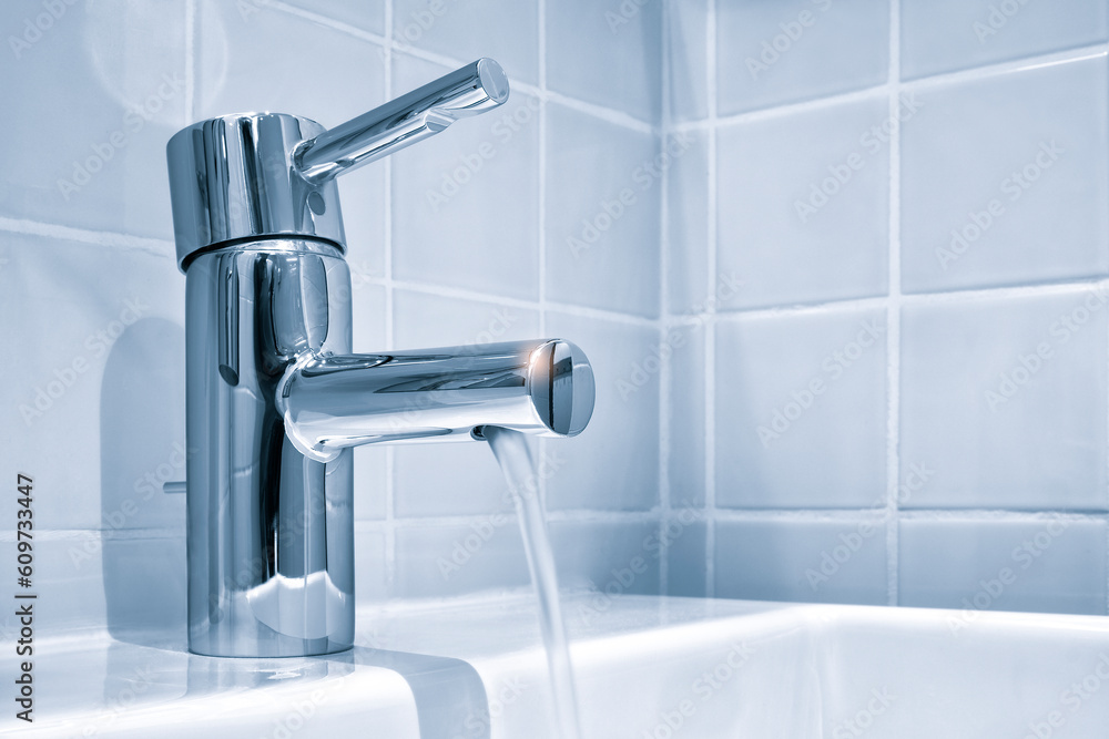 Faucet and water drop close up. Bathroom interior with sink and water tap. Flow water in bathroom with sink.