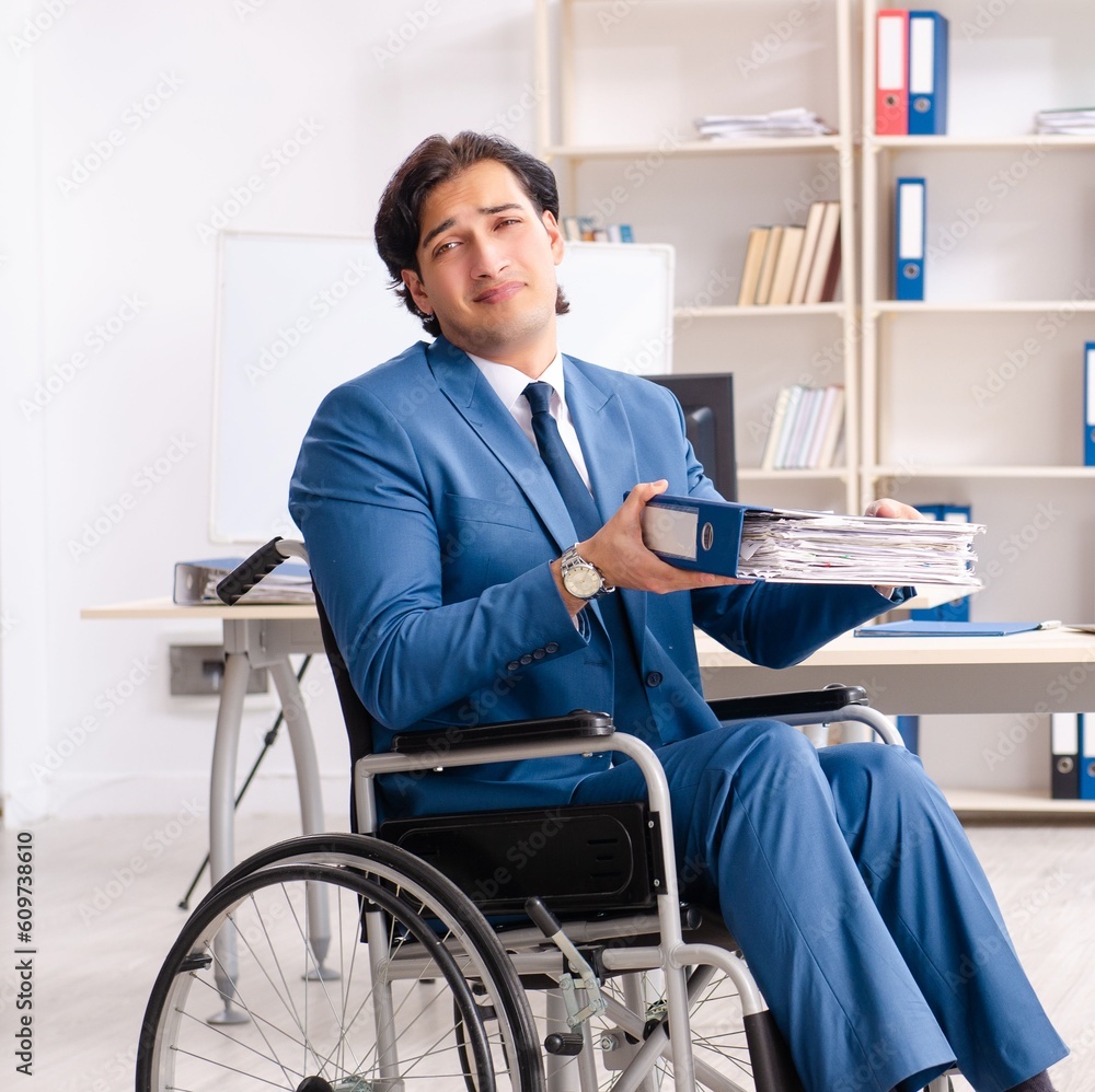Male employee in wheelchair working at the office Male employee in wheelchair working at the office