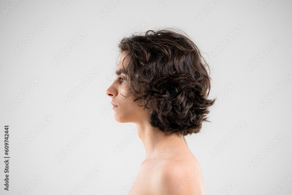 Profile of a handsome young man with lush curly hair on a white background Profile of a handsome young man with lush curly hair on a white background