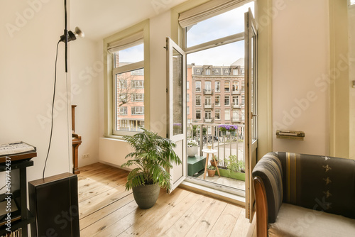 Canvas Print a living room with wood flooring and large windows looking out onto the cityscap