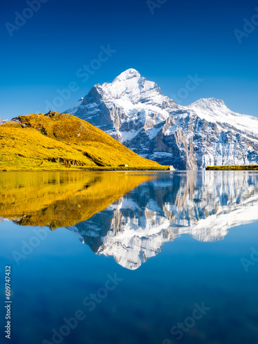 Swiss landscape. High mountains and reflection on the surface of the lake. Mountain valley with lake. Landscape in the highlands in the summertime. Travel and vacation.