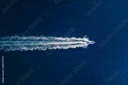 Fototapeta Naklejka Na Ścianę i Meble -  Vacation and leisure. Aerial view on fast boat on blue Mediterranean sea at sunny day. Fast ship on the sea surface. Seascape from the drone. Seascape from air. TSeascape with motorboat.