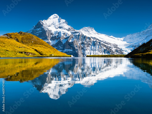 Swiss landscape. High mountains and reflection on the surface of the lake. Mountain valley with lake. Landscape in the highlands in the summertime. Travel and vacation.