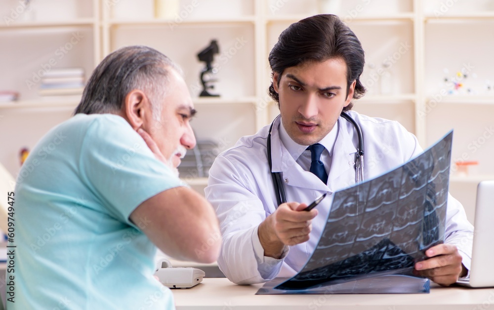 Old man visiting young male doctor Old man visiting young male doctor