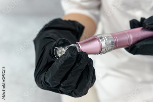 Dermis stamp electric pen. Dermapen. Needle mesotherapy treatment close up in cosmetologist hands for medical procedure 