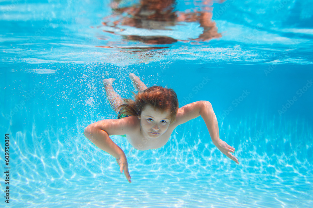 Underwater boy in the swimming pool. Cute kid boy swimming in pool under water. Summer vacation with children. Active healthy holiday.