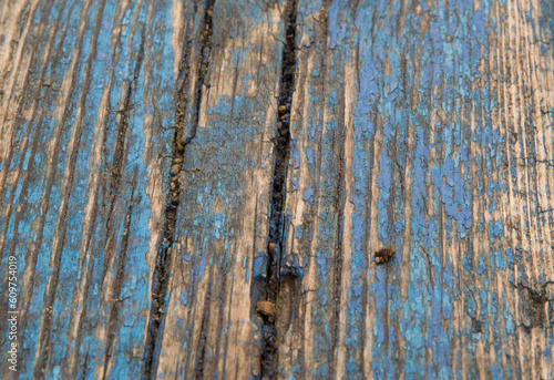 close-up: blue paint wooden seat with peeled off paint stripes photo