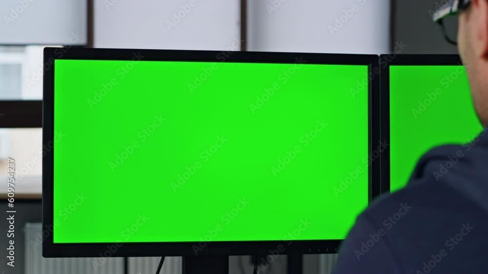 Two green pc monitor in office closeup. Professional designer manager working Two green pc monitor in office closeup. Professional designer manager working