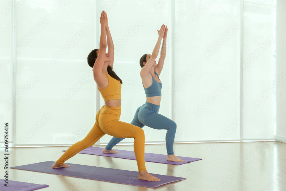 Obraz premium Two young Mexican women practicing yoga indoors in a studio
