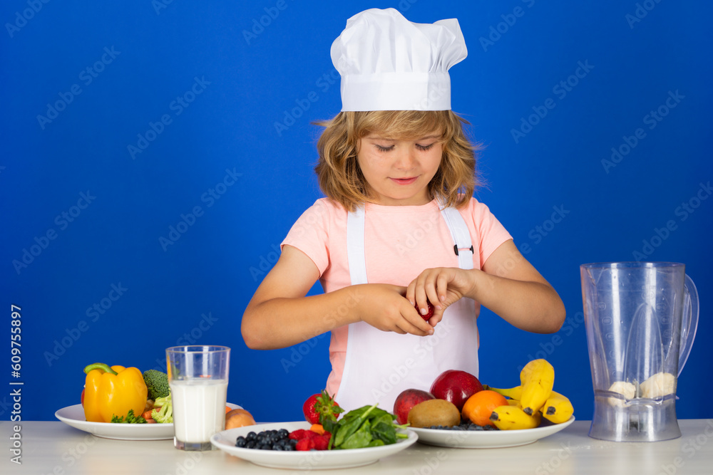 Child chef dressed cook baker apron and chef hat isolated on studio background. Healthy nutrition kids food. Child chef dressed cook baker apron and chef hat isolated on studio background. Healthy nutrition kids food.
