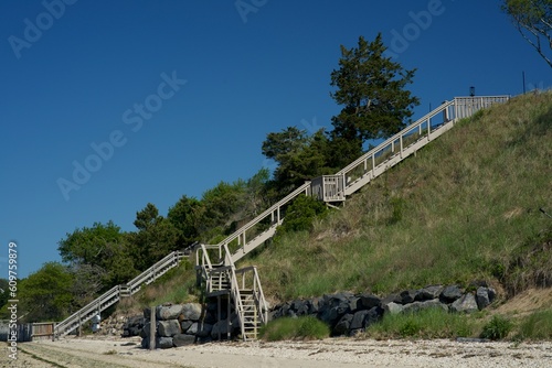 Canvas Print Long wooden stairways from beach up tall, grassy hill