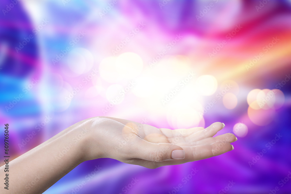 Aura phenomena. Woman with lights of energy coming out from her hand against color background, closeup Aura phenomena. Woman with lights of energy coming out from her hand against color background, closeup