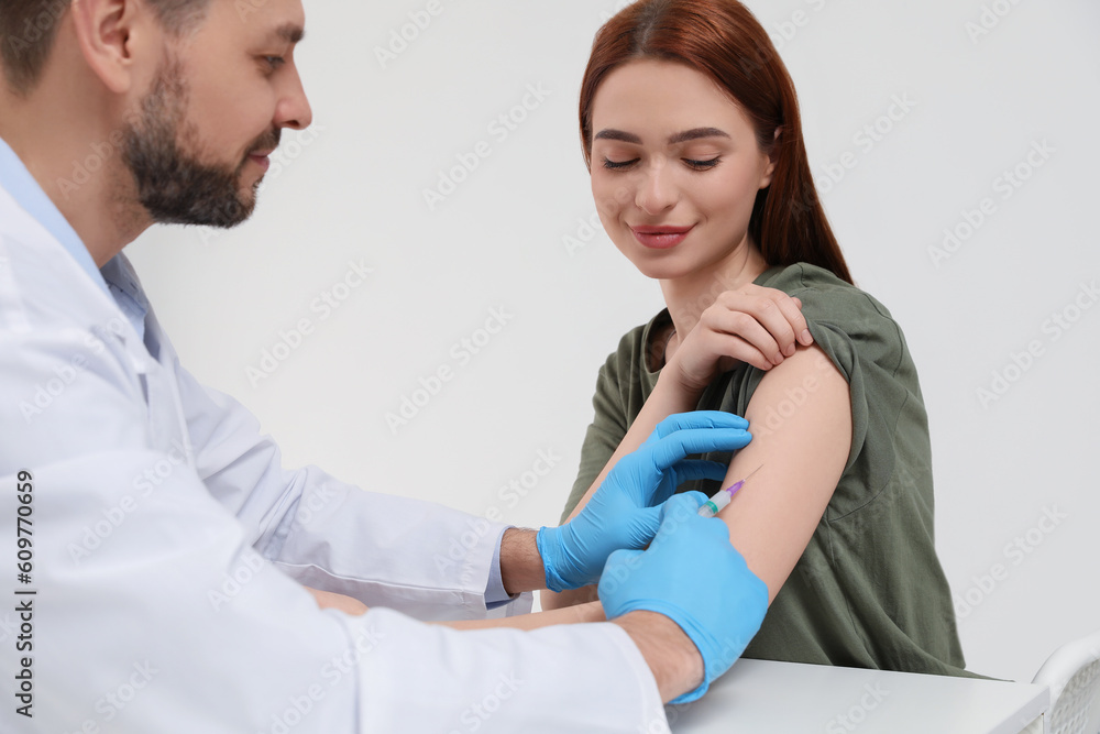 Doctor giving hepatitis vaccine to patient in clinic Doctor giving hepatitis vaccine to patient in clinic