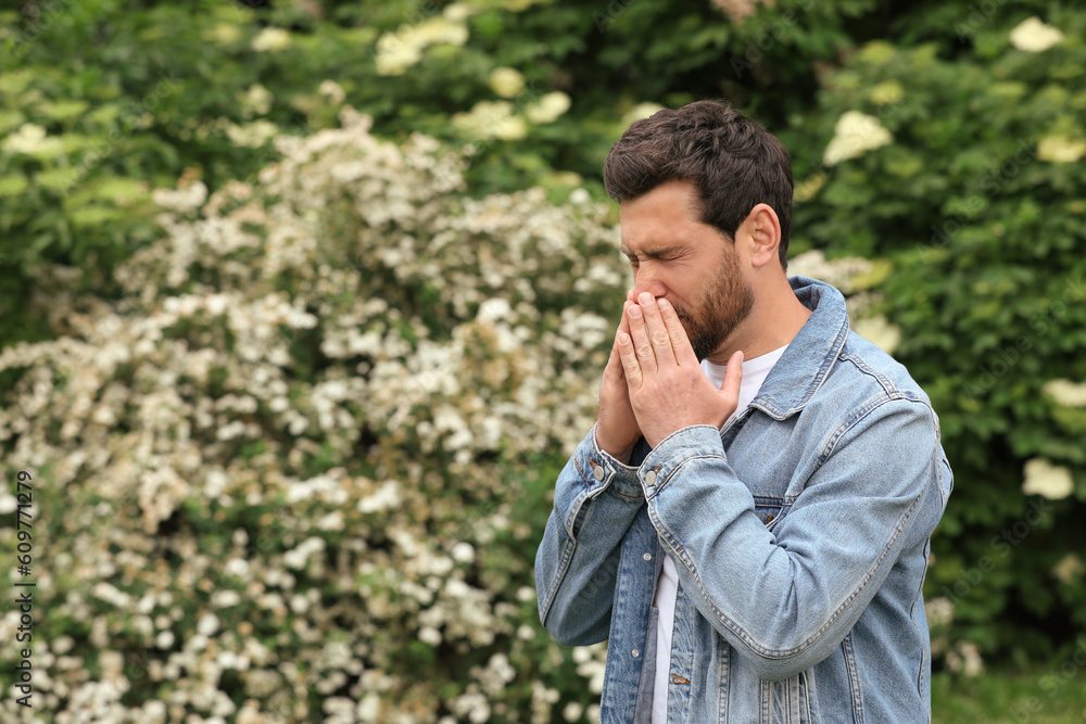 Man suffering from seasonal pollen allergy on spring day, space for text Man suffering from seasonal pollen allergy on spring day, space for text