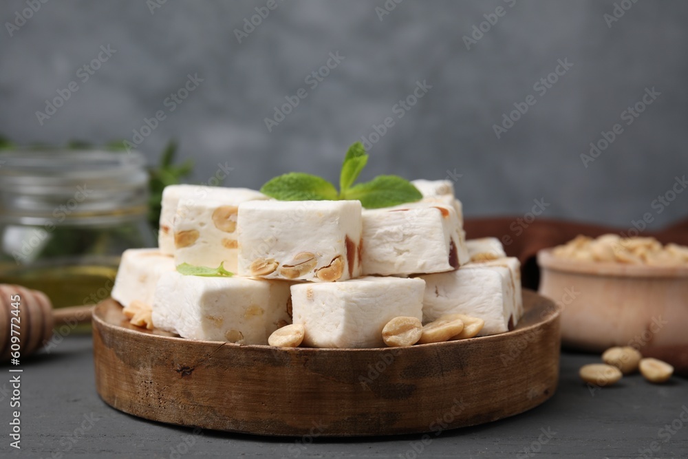 Pieces of delicious nougat and nuts on wooden board, closeup