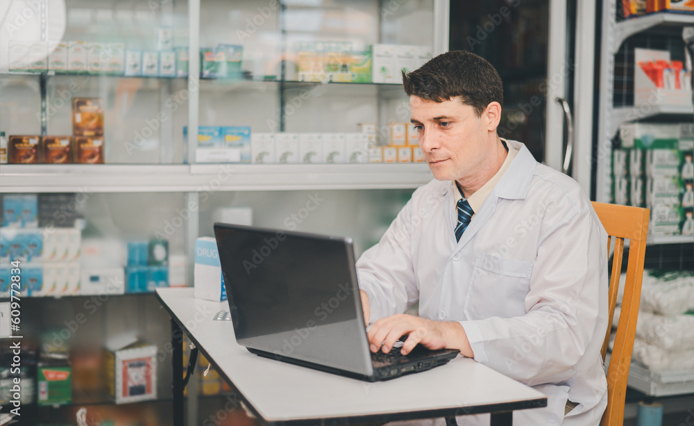 Male pharmacist checking, analyzing or Checks Inventory of Medicine, Drugs, Vitamins and checking prescription drugs for patients in modern pharmacy