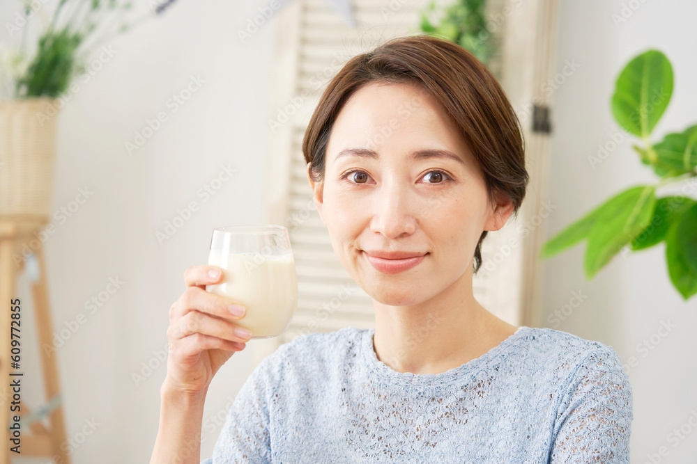 自宅で豆乳を飲む女性　カメラ目線