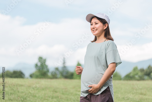 公園で運動・散歩・ウォーキング・有酸素運動・ランニングする妊婦の女性 