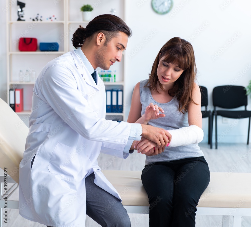 Fototapeta premium Young woman visiting male doctor traumatologist