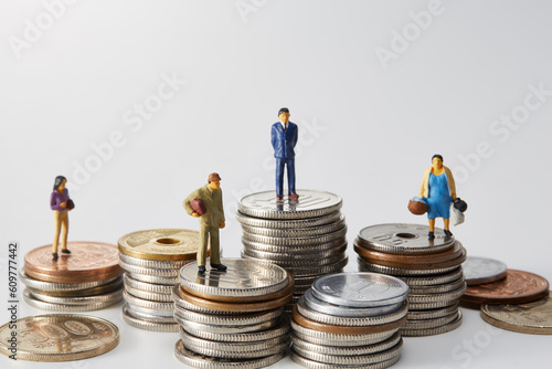 積み重ねられた日本の硬貨の上に立つミニチュアの人々