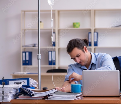 Young male employee suffering at workplace