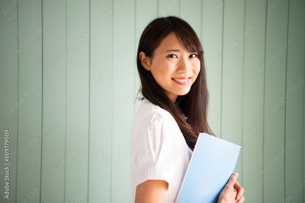 ノートを抱えて笑っている働く女性