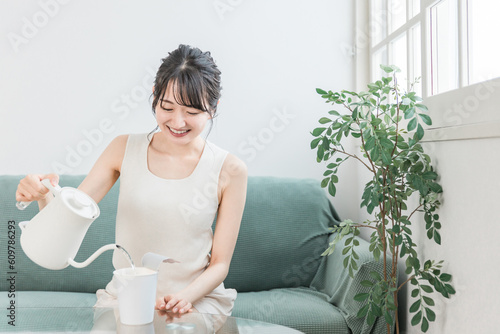 家でカップラーメンにケトルでお湯を注ぐアジア人女性
 photo
