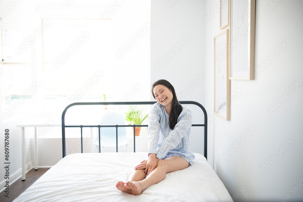 ベッドの上に座っているパジャマ姿の女性 ベッドの上に座っているパジャマ姿の女性