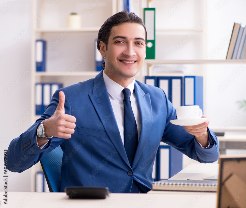 Young handsome employee in the office Young handsome employee in the office