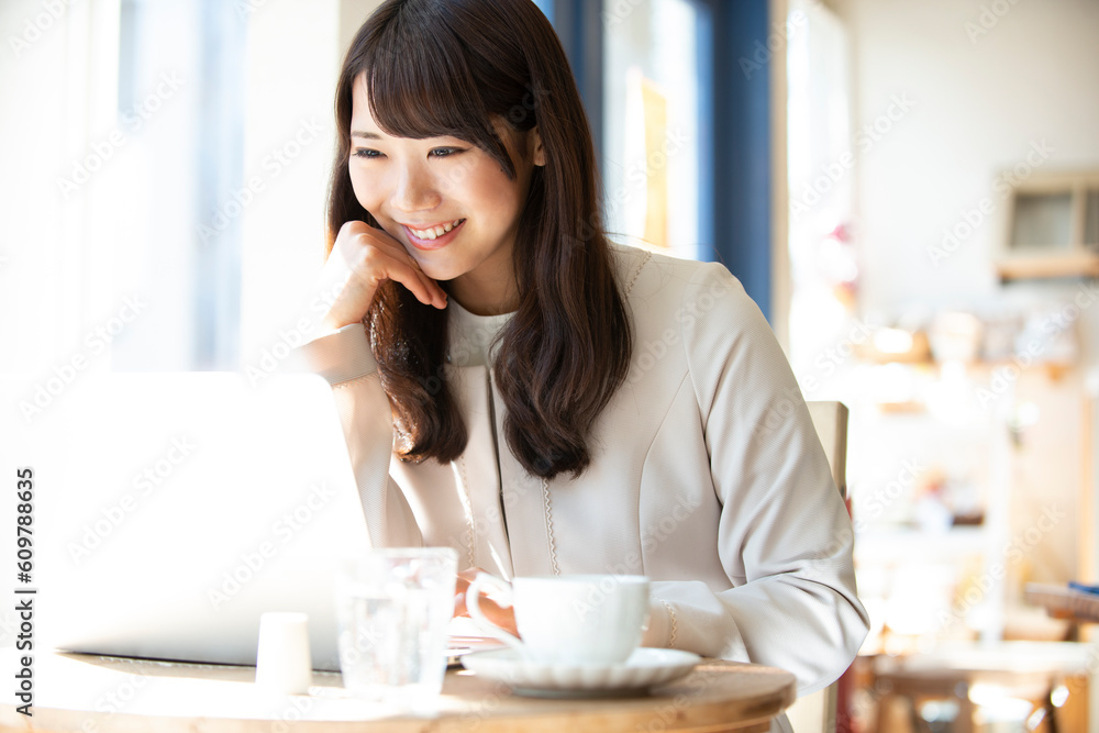 カフェでパソコンを使って仕事をしている女性 カフェでパソコンを使って仕事をしている女性