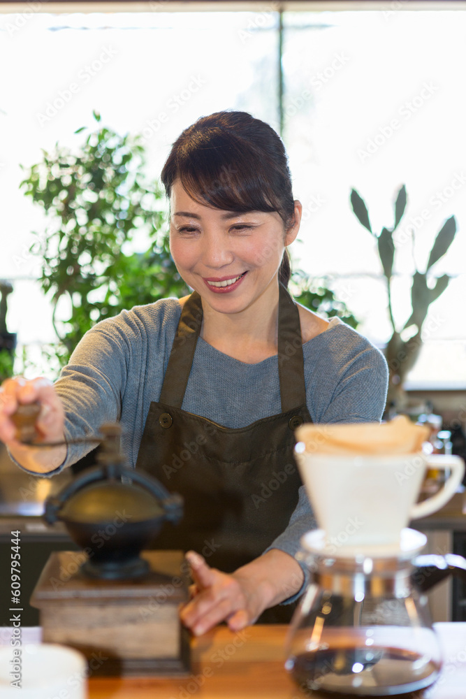 コーヒー豆を挽く女性 コーヒー豆を挽く女性