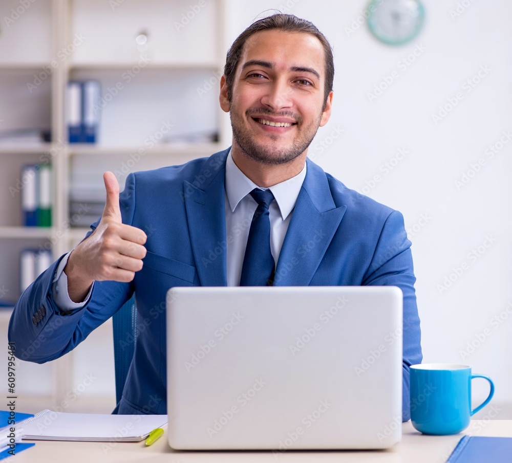 Young male employee working at workplace Young male employee working at workplace