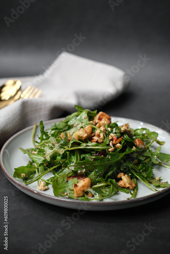 the salad plate is made with green arugula and balsamic dressing for Mediterranean diet and vegetarian diet.