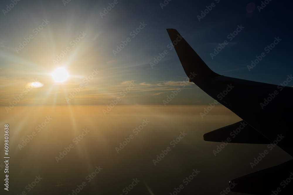 View from airplane on the aircraft white wing flying over desert landscape in sunny morning. Air travel and transportation concept. View from airplane on the aircraft white wing flying over desert landscape in sunny morning. Air travel and transportation concept.