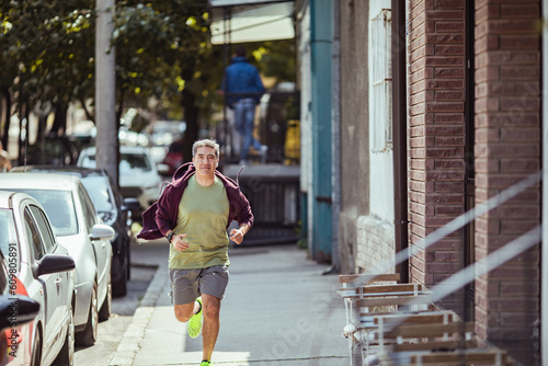 Middle aged latin man jogging in the city © Baba Images
