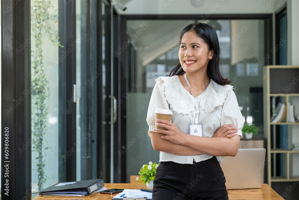 Obraz premium Young adult happy smiling businesswoman girl business owner manager officer employer hold coffee and work by laptop computer in office