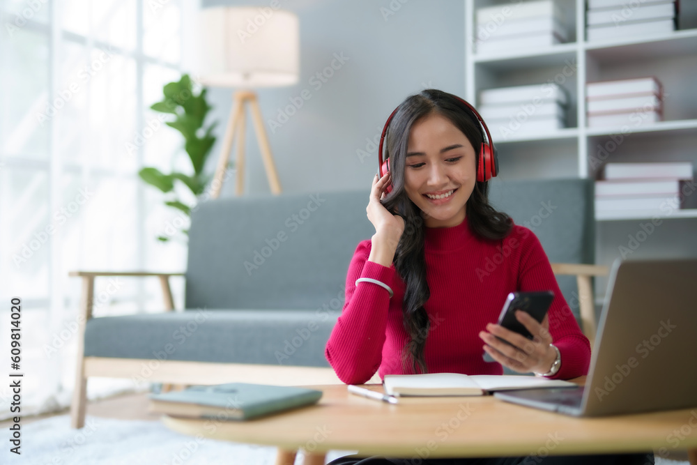 Cute Asian young woman red shirt is using mobile phone sitting on the floor in the living room, watching movie, listening to music, shopping online, watching live broadcast. Cute Asian young woman red shirt is using mobile phone sitting on the floor in the living room, watching movie, listening to music, shopping online, watching live broadcast.