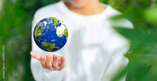 Man holding the earth in front of fresh green background. Environmental protection concept.