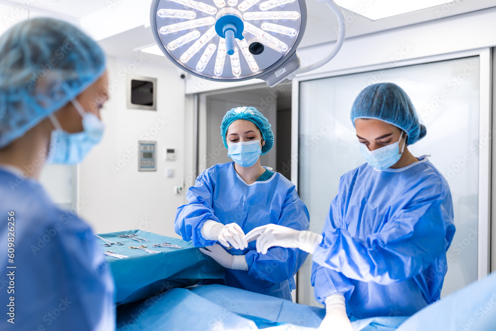 Shot in the Operating Room, Assistant Hands out Instruments to Surgeons During Operation. Surgeons Perform Operation. Professional Medical Doctors Performing Surgery. Shot in the Operating Room, Assistant Hands out Instruments to Surgeons During Operation. Surgeons Perform Operation. Professional Medical Doctors Performing Surgery.