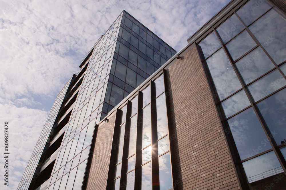 Modern office building with glass facade and blue sky. Business background. modern architecture in the city Modern office building with glass facade and blue sky. Business background. modern architecture in the city