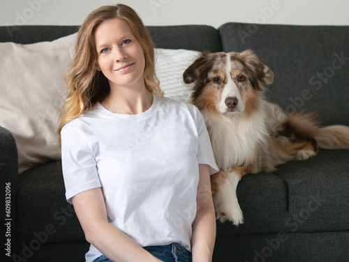 Frau mit Hund Australian Shepherd weißes T-Shirt Jeans Mockup Indoor Sofa Zuhause Kissen Couch