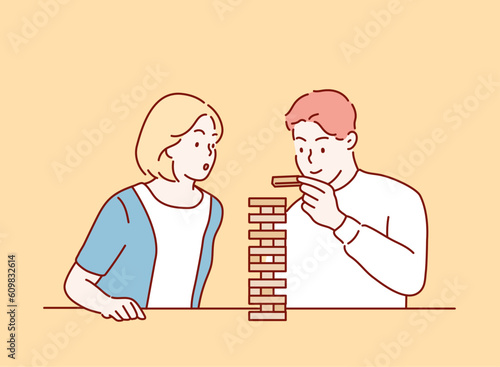 Happy couple playing game of wooden towers. Hand drawn style vector design illustrations.