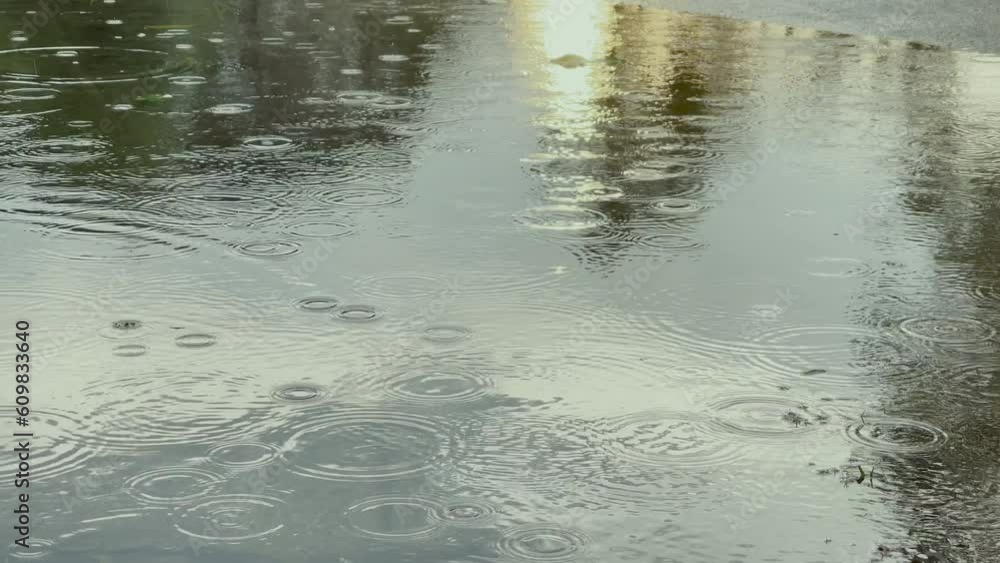 Rain water drops falling into big puddle , flooding the street. Rain water drops falling into big puddle , flooding the street.