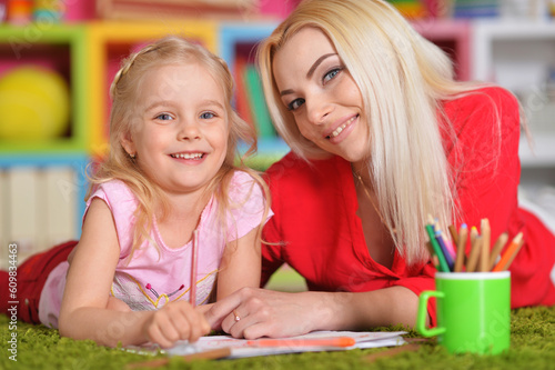 Beautiful mother and daughter drawing with her little girl