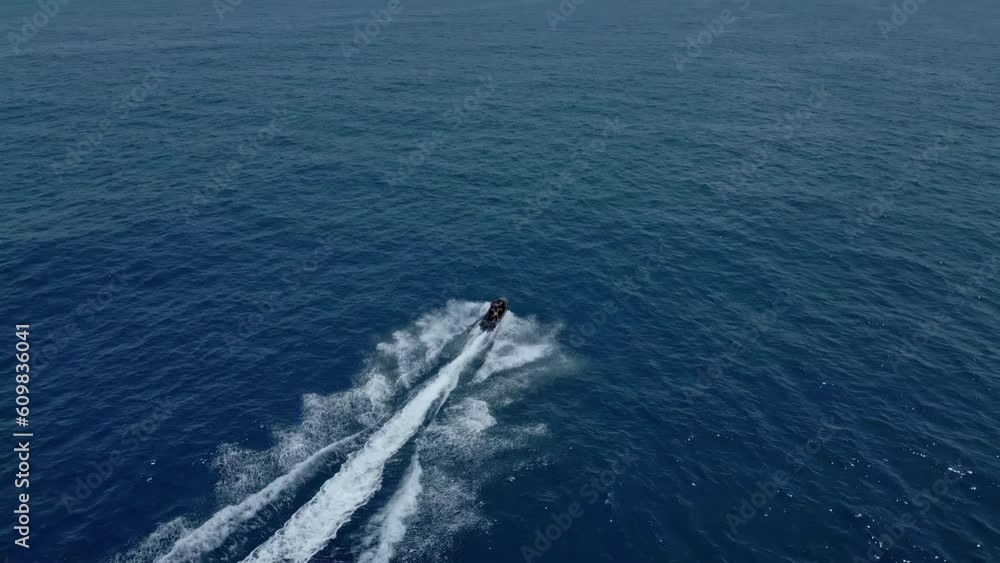 Two-person jet ski enjoying an thrilling ride on the ocean - aerial follow Two-person jet ski enjoying an thrilling ride on the ocean - aerial follow