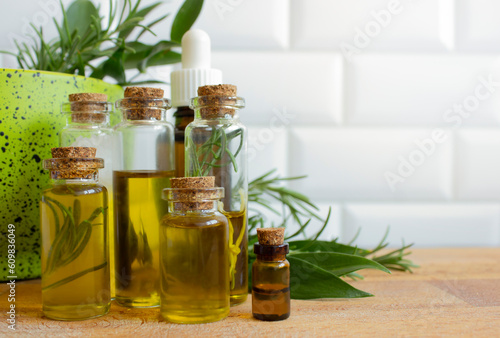 Essential oils and fresh herbs on a light background, copy space.