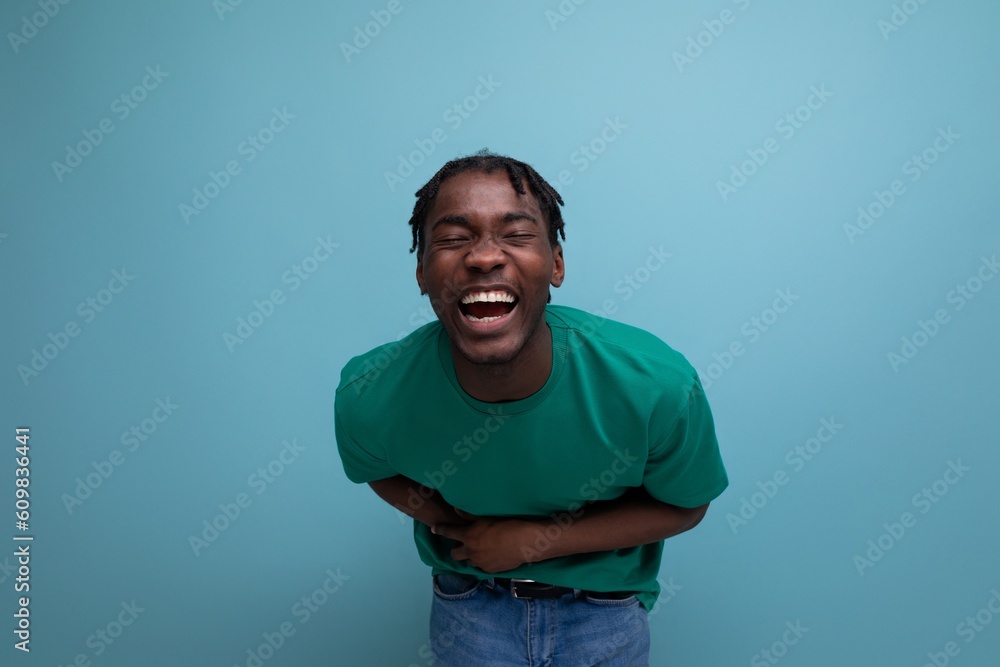 handsome american young man in casual green t-shirt on blue background handsome american young man in casual green t-shirt on blue background