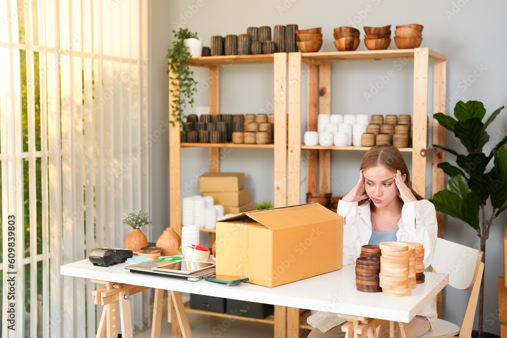 Fototapeta premium Caucasian young seller woman headache while thinking about handmade product quality and packaging design problem for customer online in office store