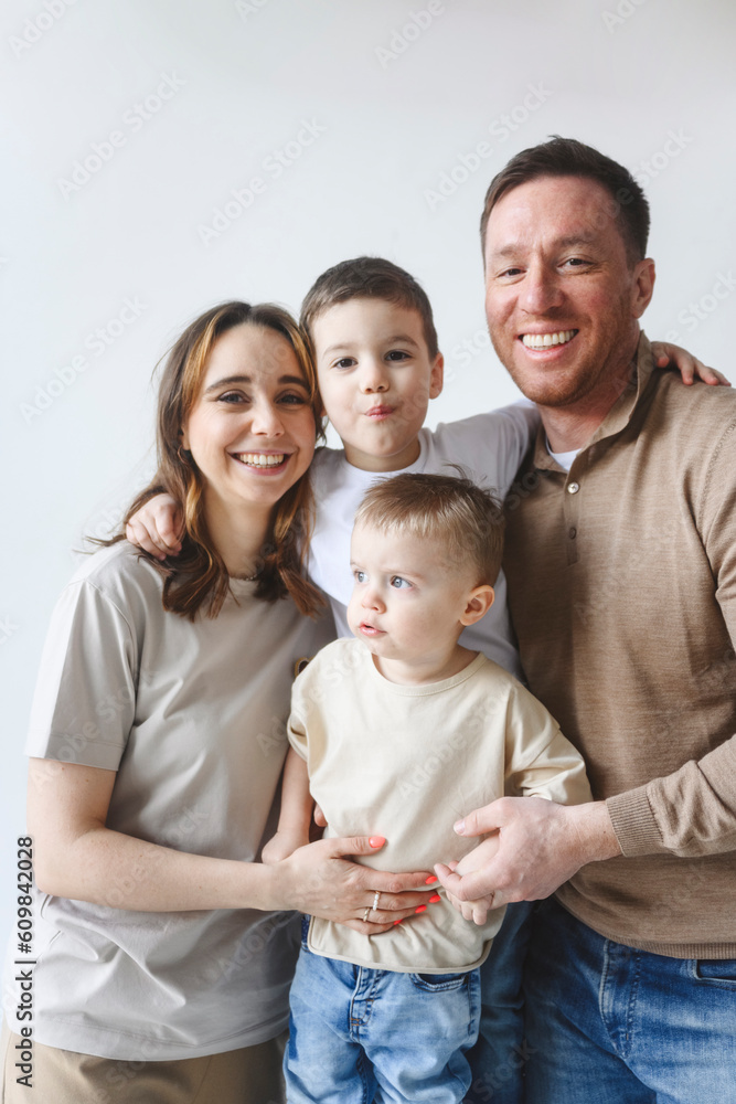Happy father and mother with sons against white background Happy father and mother with sons against white background